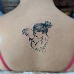 a woman with a tattoo on her back is holding a small child's head