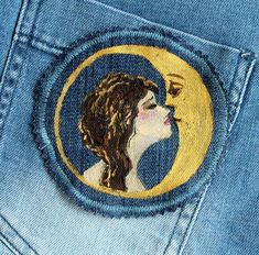 a woman's face painted on the back of a pair of blue jean pants