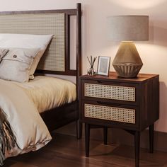 a bedroom with a bed, night stand and lamp on the side table next to it