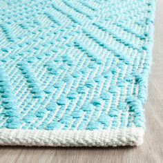 a blue and white rug on top of a wooden floor