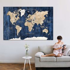 a woman sitting on a couch in front of a world map