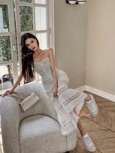 a woman sitting on top of a couch next to a window