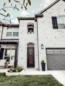 a large white brick house with two garages