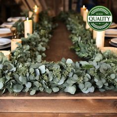 the table is set with candles and greenery