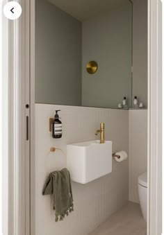 a bathroom with a sink, mirror and toilet paper dispenser on the wall