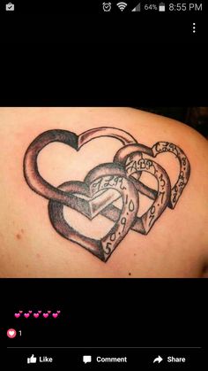 a couple of heart shaped tattoos on the back of a woman's shoulder