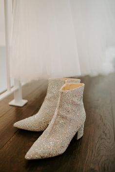 a pair of white shoes sitting on top of a wooden floor