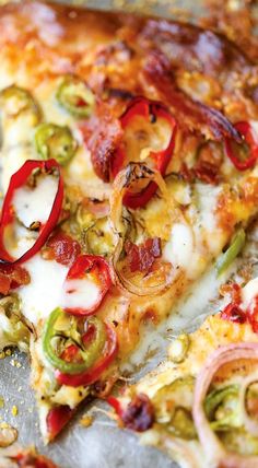 a close up of a slice of pizza with peppers and onions on it's crust