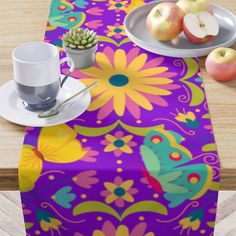 an image of a table setting with fruit and coffee cup on it, including apples