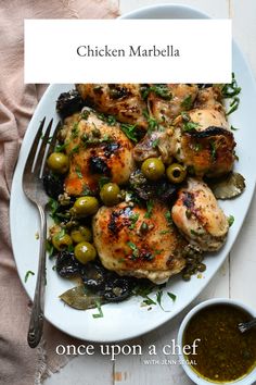 chicken marbella with olives and herbs on a white plate