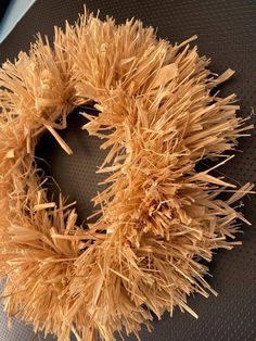 a close up of a wreath made out of wood shavings on a table