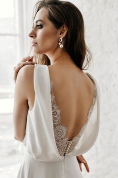 the back of a woman's wedding dress, with her hand on her shoulder