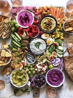 a table full of different types of food and drinks, including dips, crackers