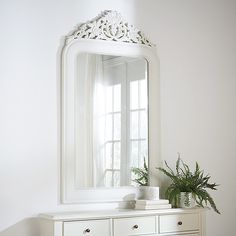 A dramatic five feet in height, our stately Windsor Mirror makes a grand statement above a mantel, entryway console, or dining room server. The frame is handmade of mango wood with ivory finish and crowned with an elegantly carved floral crest. Delicate beading accentuates the mirror's rounded shoulder silhouette.  Windsor Mirror features:  Hand carved. Ivory finish. Mango wood, engineered hardwood & glass. Hangs vertically. Strong French cleat hanger with expansion bolts included. Ballard Scalloped Mirror, White Ornate Mirror, Wooden Carved Mirror Frames, Banquette Dining, Dining Room Server, Outdoor Umbrella Stand, Holiday Furniture, Rug Runner Kitchen, Daybed With Storage