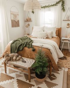 a bedroom with white walls and wooden floors, decorated in neutral colors including green accents