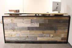 a reception desk made out of wood with a computer monitor on it's top