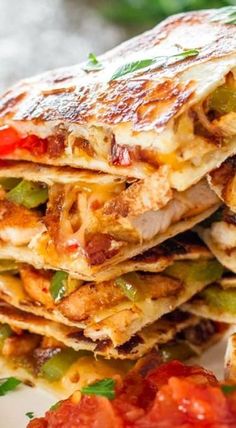 a stack of quesadillas stacked on top of each other with toppings