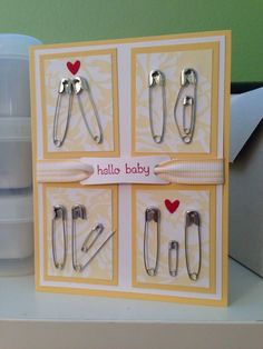 a card with scissors and clips attached to the front of it, which says hello baby