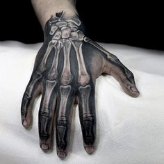 a hand with tattoos on it and the words get a skeleton hand tattooed for halloween