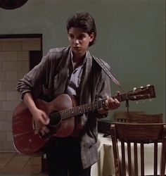 a young man is playing an acoustic guitar