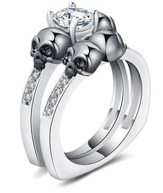 two skulls on each side of the wedding ring, with white diamonds in their claws