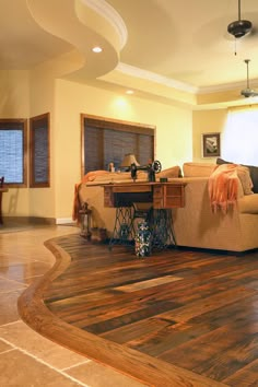 a living room filled with furniture and a wooden floor covered in hard wood planks