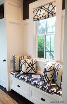 a window seat with pillows on it in front of a white door and windowsill