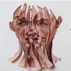 a woman's face is made out of strips of wood and paper with her eyes closed