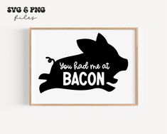 a black and white print with the words you had me at bacon on it, in front of a wooden frame