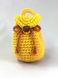 a crocheted yellow purse with a brown handle