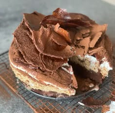 a chocolate cake on a cooling rack with one piece missing from it's side