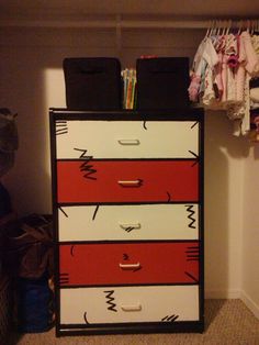 a chest of drawers in a closet with clothes hanging on the wall and other items