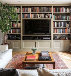 a living room filled with lots of books and furniture