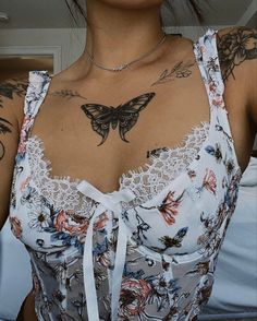 a woman with tattoos on her chest wearing a dress