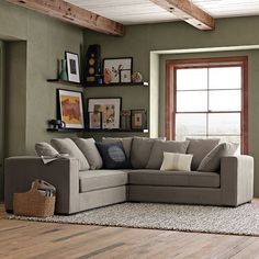 a living room filled with furniture next to a large window and wooden floored walls