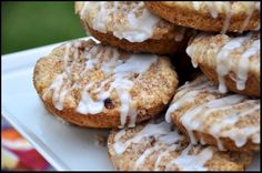 a white plate topped with donuts covered in icing and cinnamon on top of each other