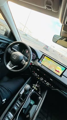 the interior of a car with dashboard, steering wheel and display screen showing driving directions