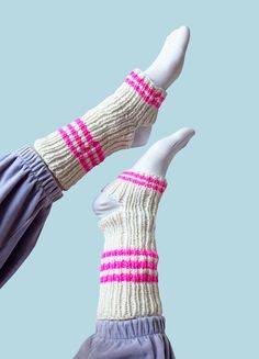 two pairs of socks with pink and white stripes are shown from the bottom up against a blue background