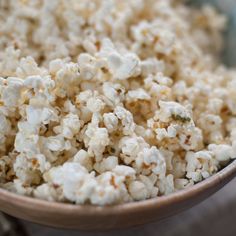 a bowl filled with popcorn sitting on top of a wooden table