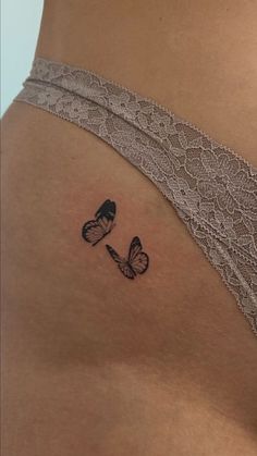 a woman's stomach with a butterfly tattoo on her left side ribcage