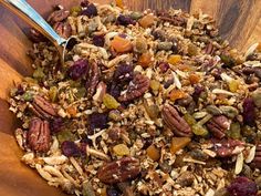 a wooden bowl filled with granola and nuts