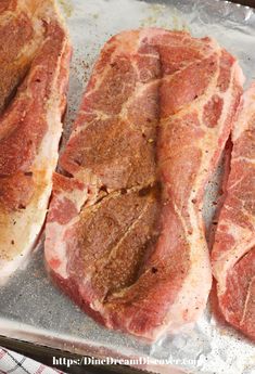 four pieces of raw meat sitting on top of a piece of tin foil covered in seasoning