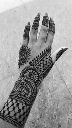 a woman's hand with henna tattoos on it