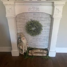 a white fireplace with a wreath on it