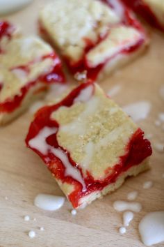 four pieces of cake sitting on top of a wooden cutting board