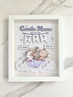 a baby's birth gift in a white frame with a teddy bear and an umbrella