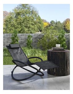 a black rocking chair sitting next to a tree stump