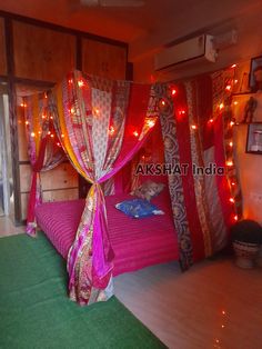 a bedroom decorated in pink and gold with lights on the ceiling, bedding and curtains