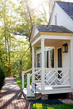 a white house with black shutters on the front porch