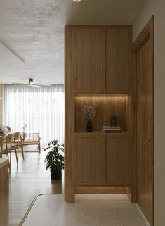 a room that has some plants on the shelf in front of it and a table with chairs behind it